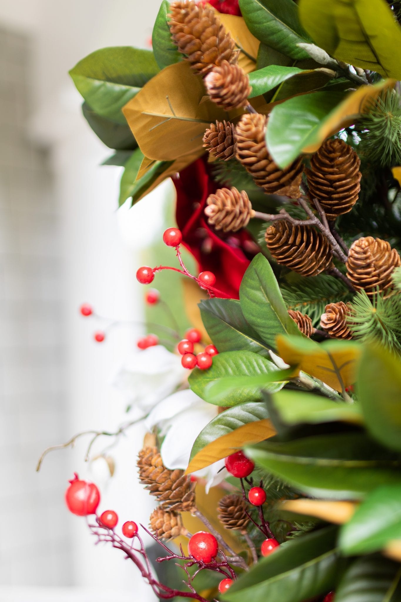 To create a poinsettia Christmas tree, you need basic ingredients: magnolia, poinsettia & a bit of the outdoors! This magnolia tree is beautiful both inside or for balcony christmas decorations! If you need Christmas balcony ideas, this tree along with artificial poinsettia plants for outside may be just the ticket!