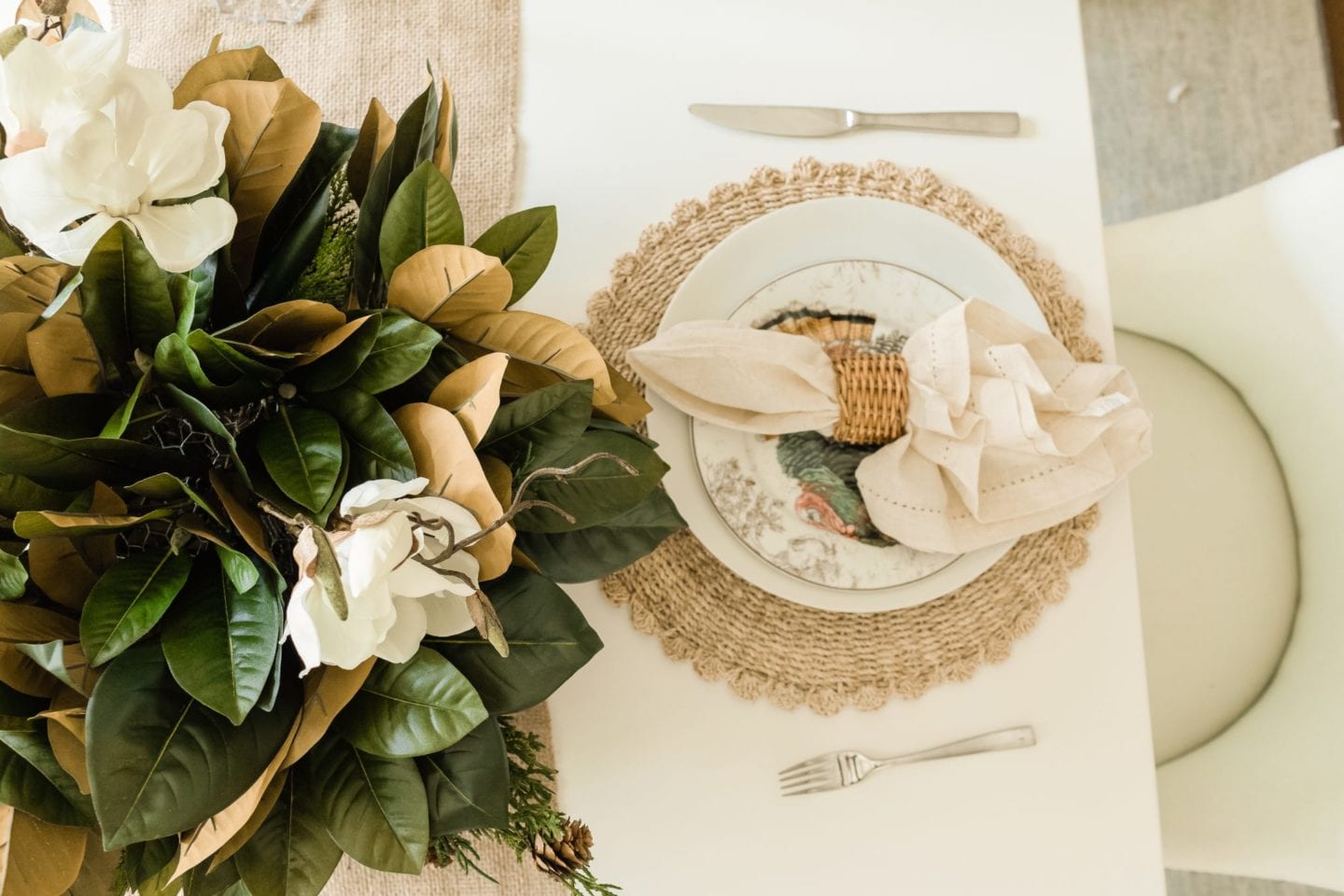 Farmhouse Thanksgiving table has a rustic feel with burlap, birch, silk magnolia and wicker.