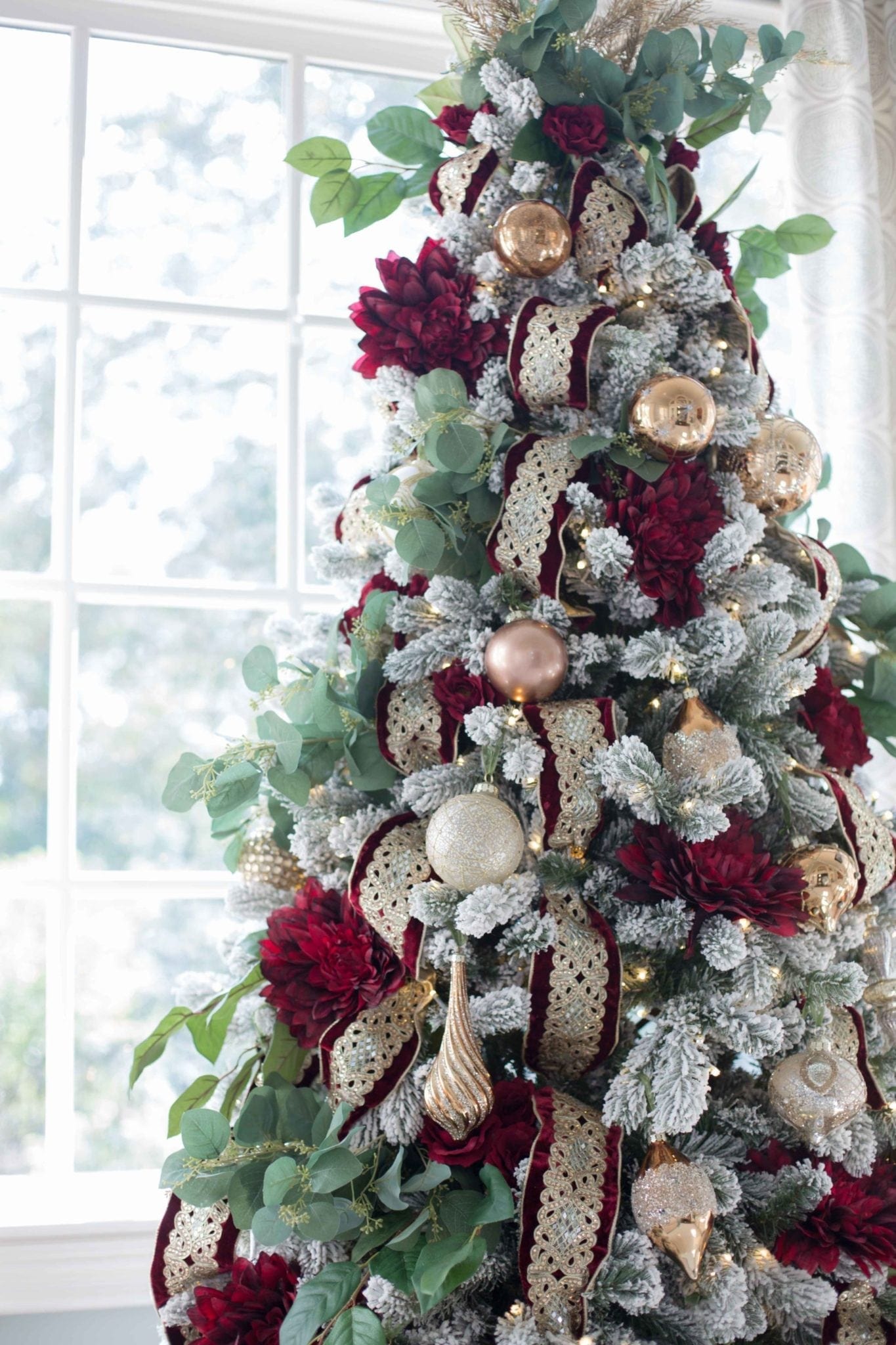 Flocked christmas tree with red and green ornaments.