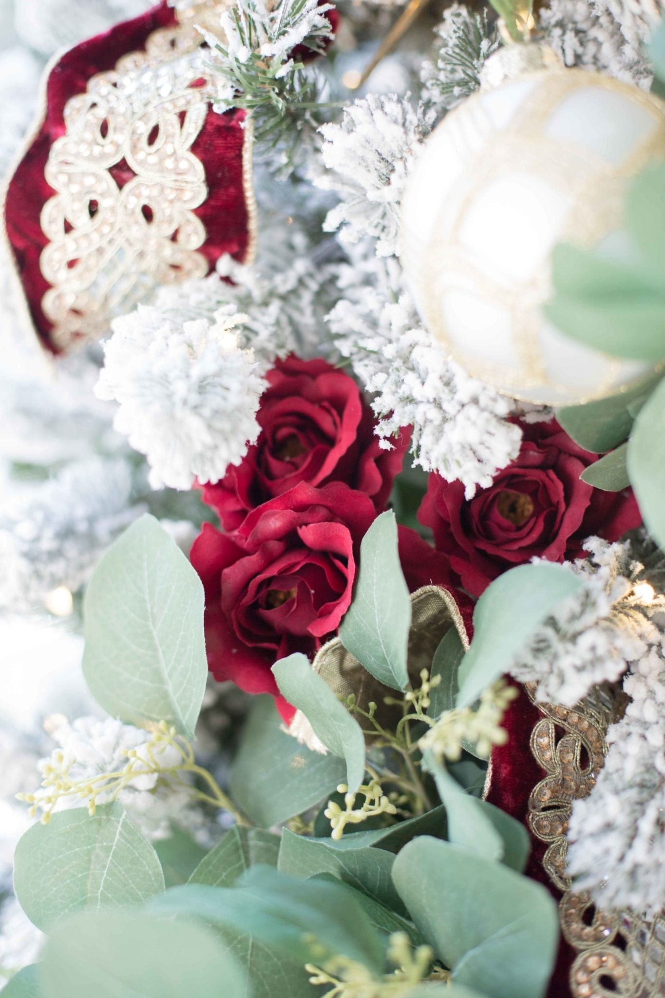 Red Christmas Rose Christmas tree fills out a white flocked Christmas tree.