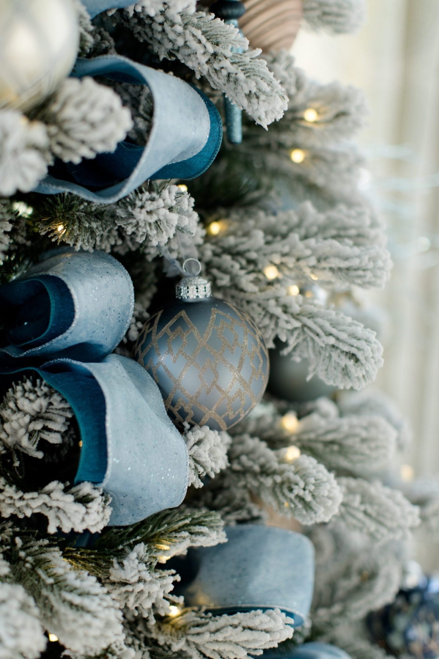 Light blue christmas ornaments with blue Christmas ball ornaments from Frontgate on flocked Christmas tree.