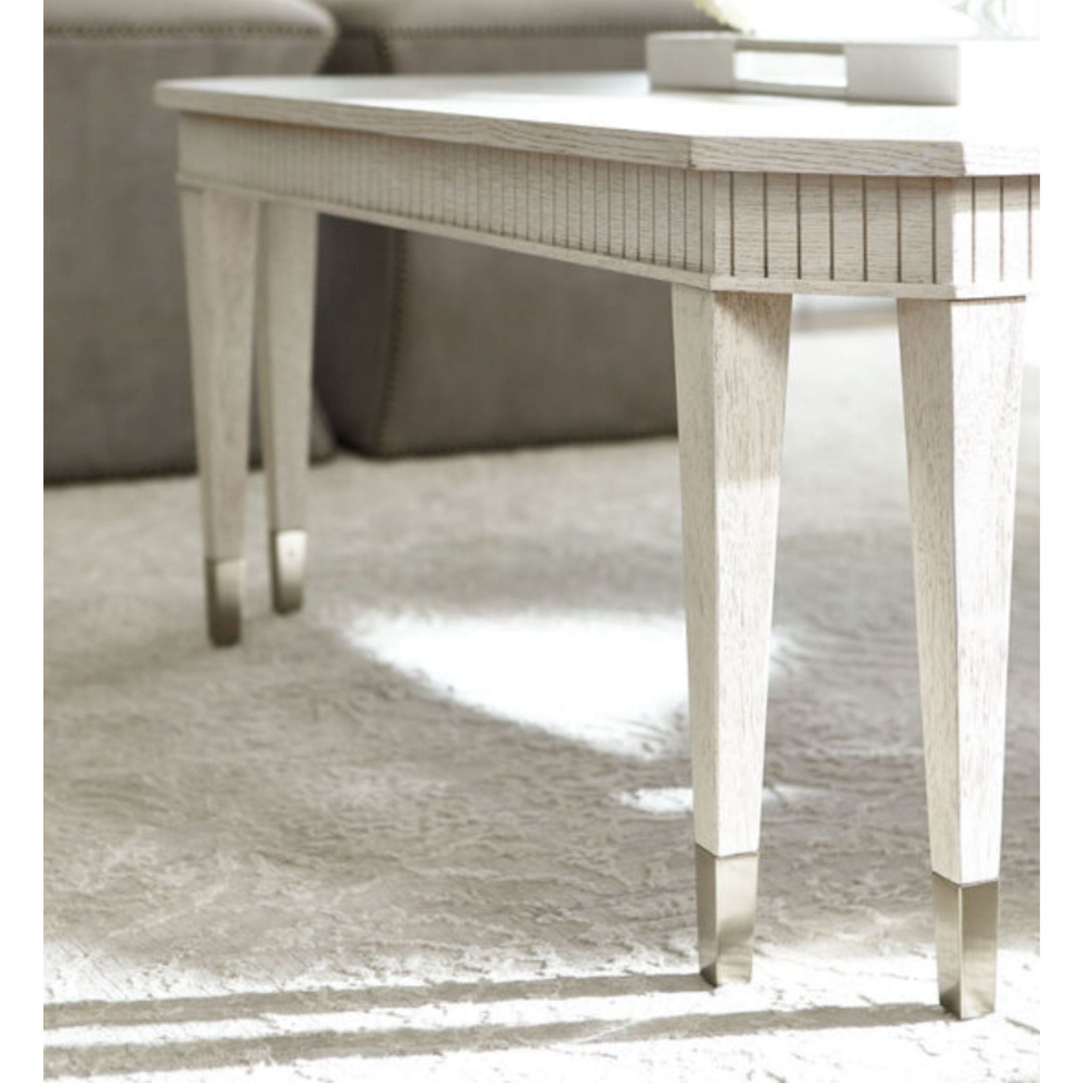 Oak light wood coffee table with clipped corners and vertical molding.