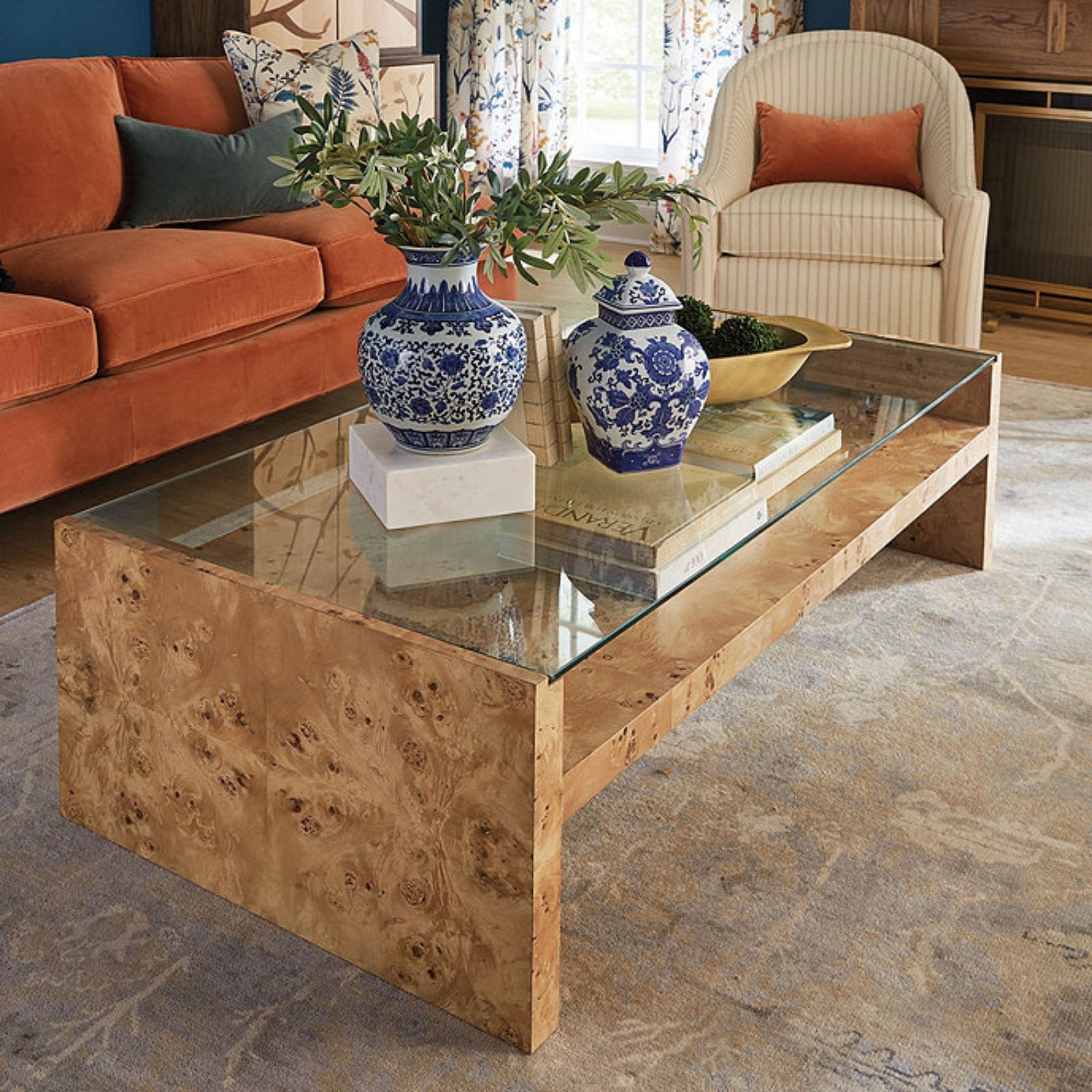 Burl wood coffee table with glass top and small storage.