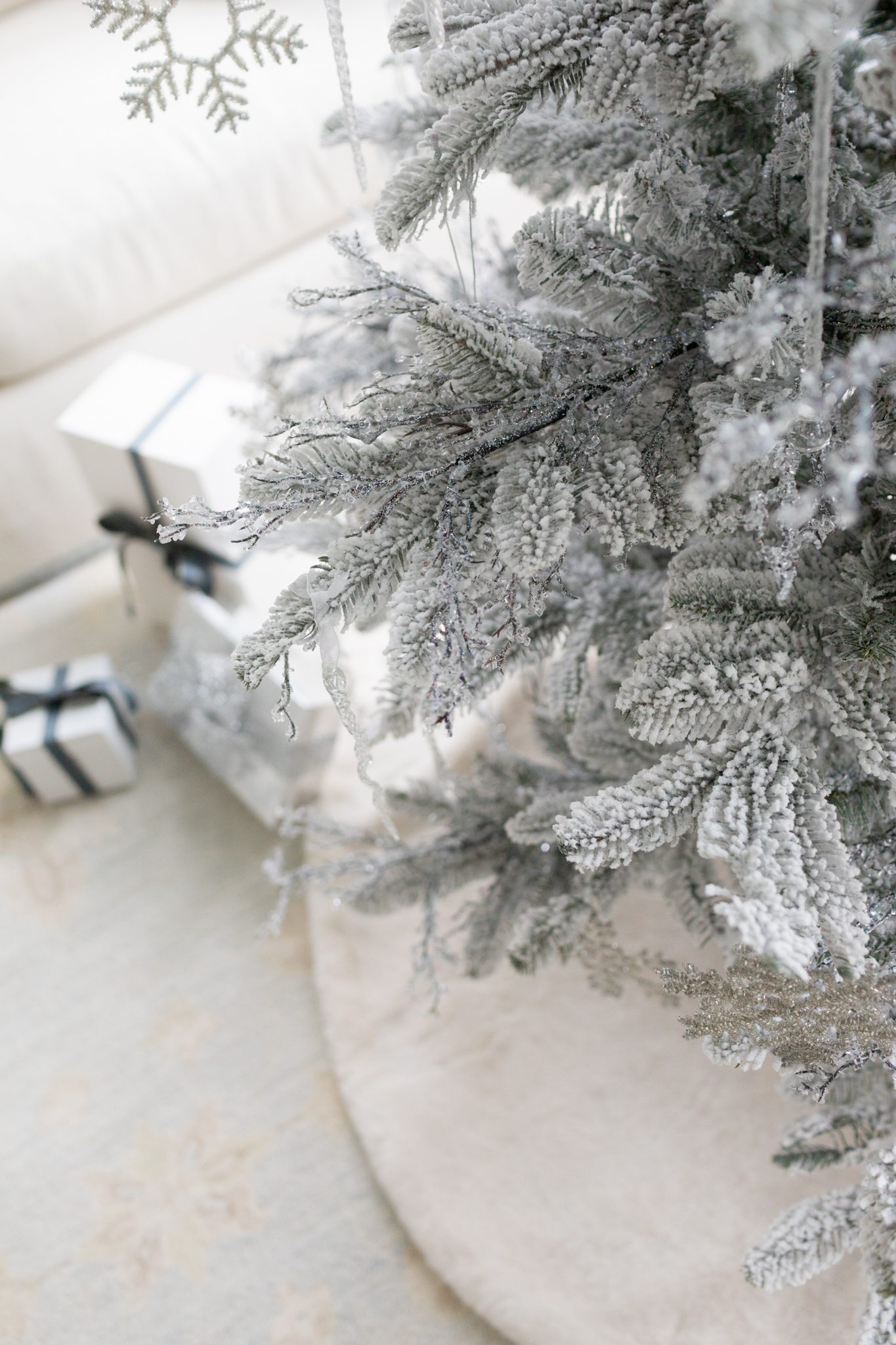 Snowflake ornament on a Christmas tree flocked.