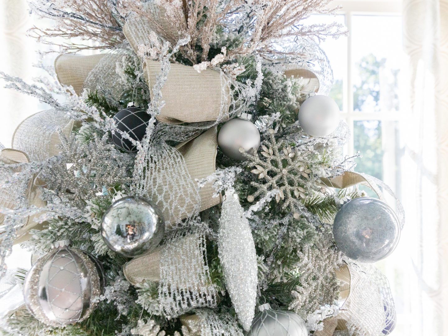 Mesh and silver ribbon on a flocked Christmas tree with silver ornaments