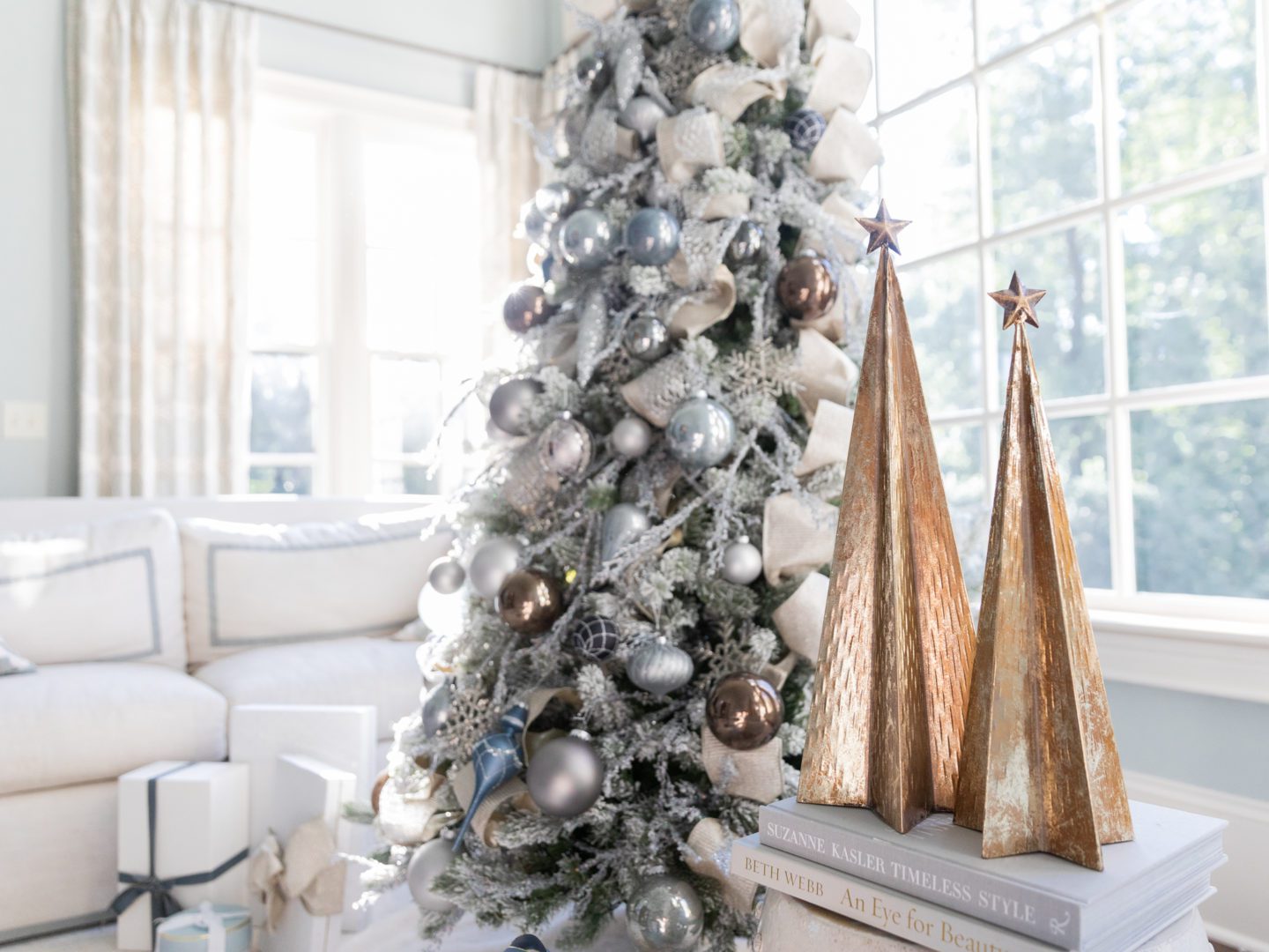 Gold fake trees next to a silver and blue Christmas tree