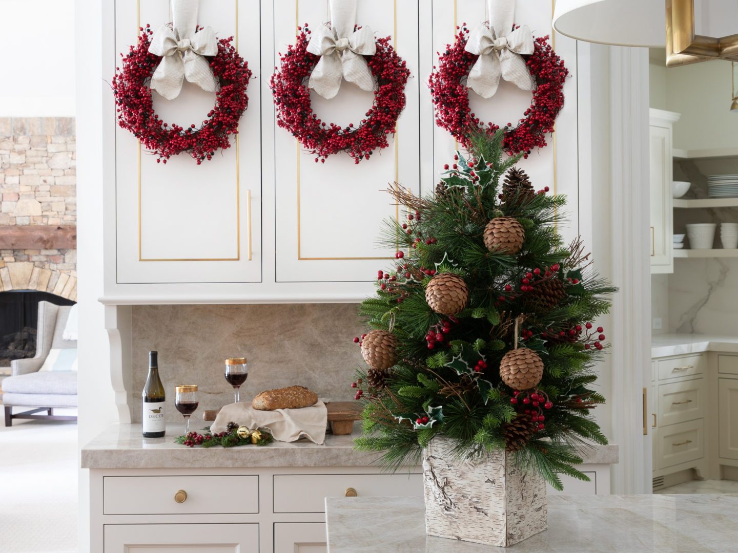 Tiny green Christmas tree on a kitchen counter with pinecone ornaments