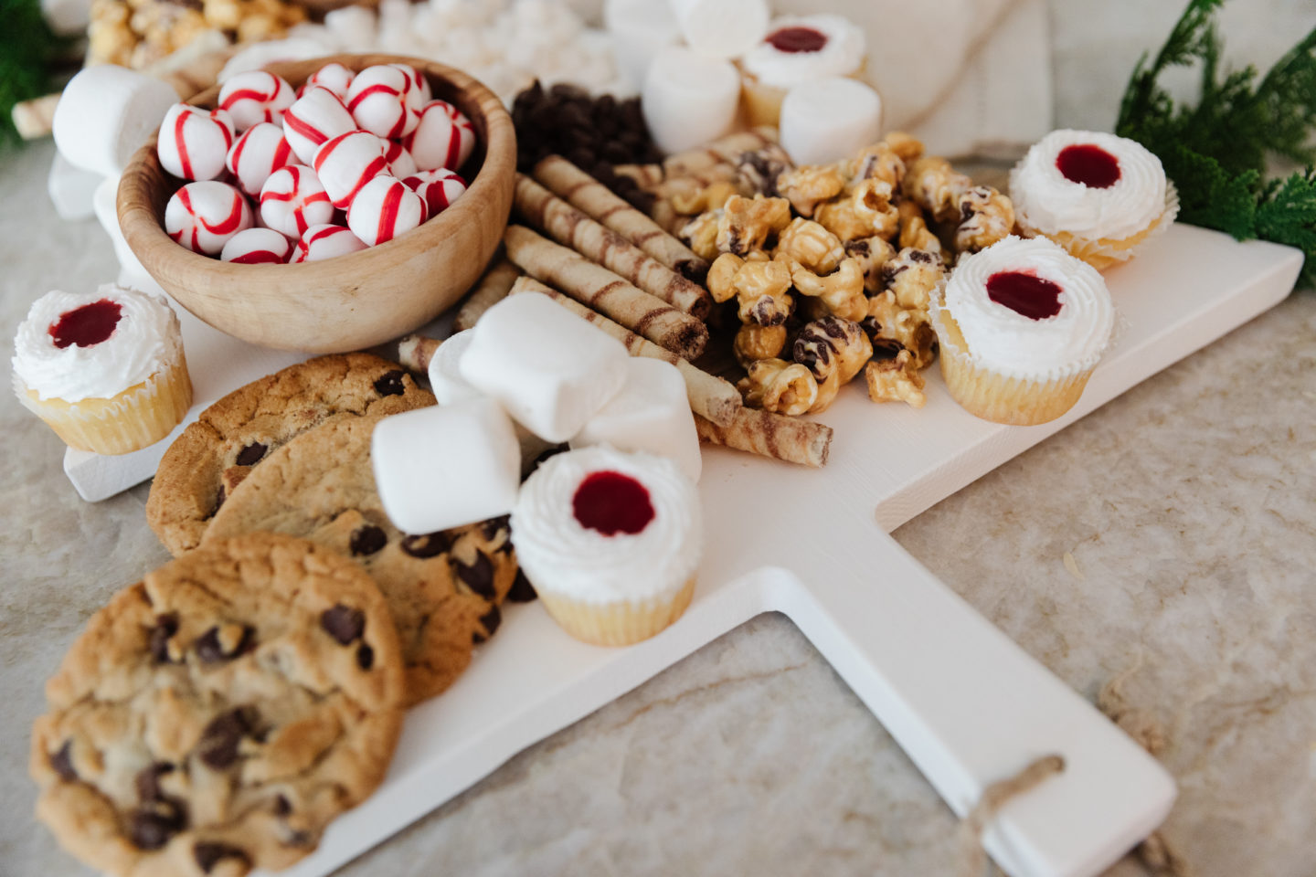 Christmas Tree Cheese Board used as a Holiday Charcuterie Board full of candy and cookies for holiday party snack idea.